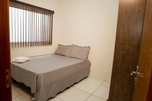 a bedroom with a bed and a window and a door at 203-FLAT-Espaço,conforto.È disso que você precisa! in Anápolis