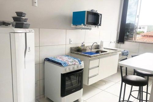 a small kitchen with a sink and a stove at 202-FLAT-Espaço,conforto.È disso que você precisa! in Anápolis