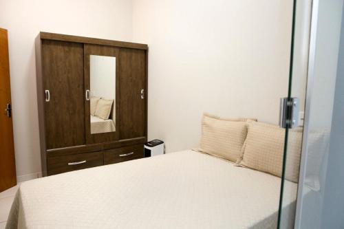 a bedroom with a bed and a dresser with a mirror at 204-FLAT-Espaço,conforto.È disso que você precisa! in Anápolis