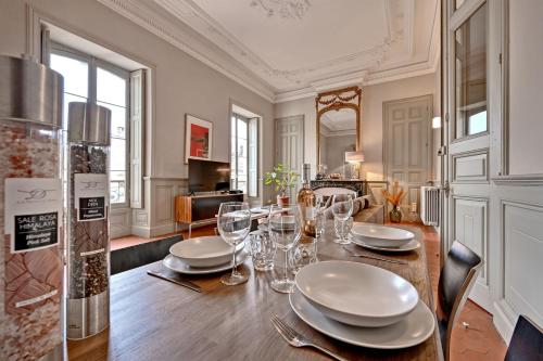 une salle à manger avec une table avec des assiettes et des verres à vin dans l'établissement Le Vieux Sextier - AC Clim - Lumineux - WIFI - Hypercentre, à Avignon