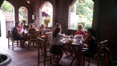 un groupe de personnes assises à table dans un restaurant dans l'établissement Tam Coc Tropical Homestay, à Ninh Binh