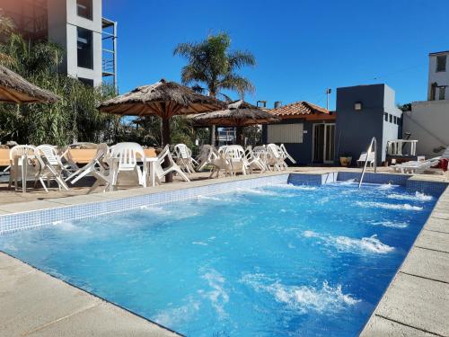 - une piscine avec des chaises longues et des parasols dans l'établissement Hotel Presidente, à Villa Carlos Paz