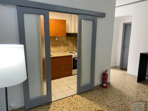 una cocina con puertas correderas de cristal en una habitación en Sunset view Rooms, en Agia Triada