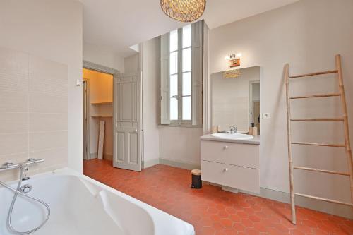 La salle de bains est pourvue d'une baignoire et d'un lavabo. dans l'établissement Le Vieux Sextier - AC Clim - Lumineux - WIFI - Hypercentre, à Avignon