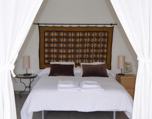 托萊多的住宿－奧利瓦鄉村民宿，卧室配有一张带两个枕头的大白色床