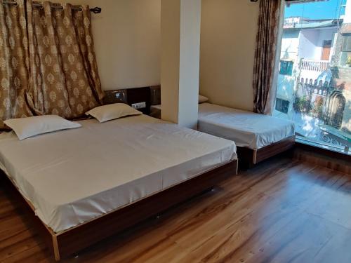 A bed or beds in a room at Hotel Shreeji Residency