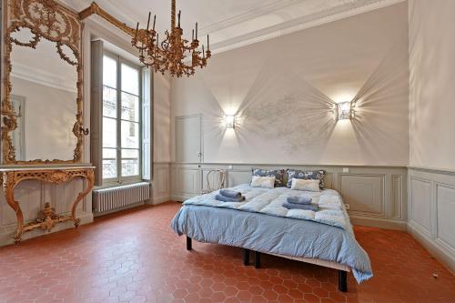 een slaapkamer met een bed en een kroonluchter bij Le Vieux Sextier - AC Clim - Lumineux - WIFI - Hypercentre in Avignon