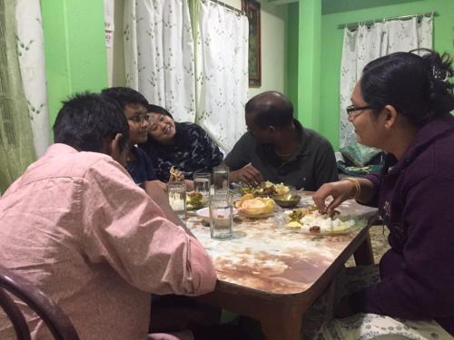 a group of people sitting around a table eating food at Swastika Homestay and Travels Kurseong Bazar Near HDFC Bank NH55 Road Kurseong in Kurseong