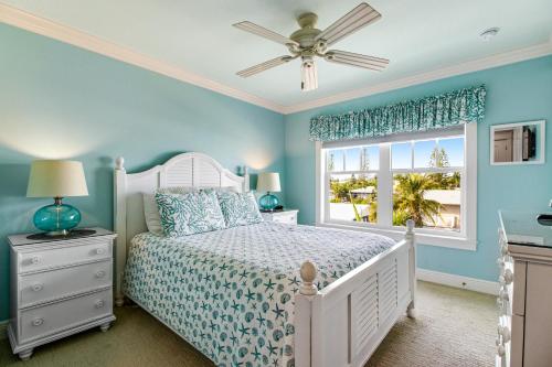 una camera da letto con un letto bianco e una finestra di LaMedeira 305 Unit A a Holmes Beach