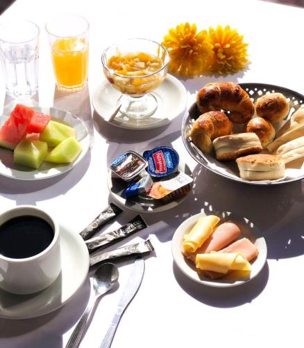 a table with plates of food and a cup of coffee at Hotel Presidente in Villa Carlos Paz