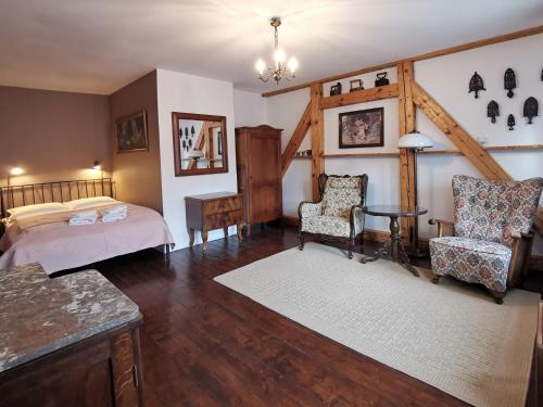een slaapkamer met een bed en een tafel en stoelen bij ZACZAROWALIM - Dom w Górach Sowich in Walim