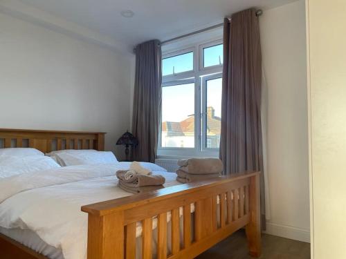 1 dormitorio con 1 cama con 2 toallas en Premium flat! Enjoy luxurious white Egyptian bedding near Gants Hill Station, Ilford, London, en Wanstead