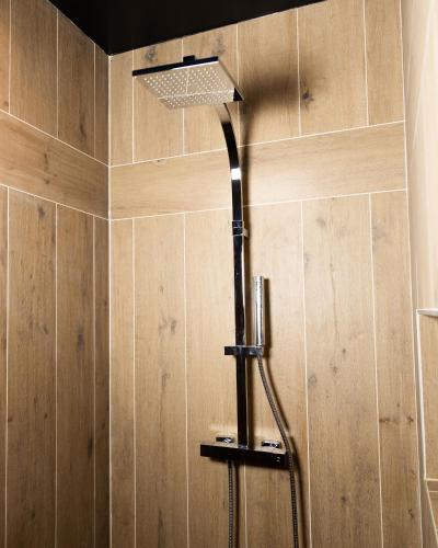 a shower in a bathroom with wooden walls at LA SUITE SEPT LE BRAS DOR in Boulogne-sur-Mer