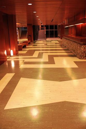 an empty hall with wooden floors and stairs in a building at Senomoto Kogen Hotel in Minamioguni