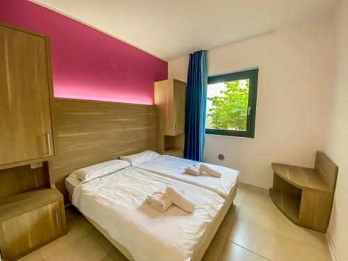 カステルヌオーヴォ・デル・ガルダにあるBelvedere Villageのベッドルーム1室(ベッド1台、タオル2枚付)
