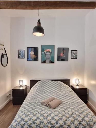 - une chambre avec un lit avec deux tables et des photos sur le mur dans l'établissement Cosy Apartments - Marseille Panier Intercontinental - City center, à Marseille