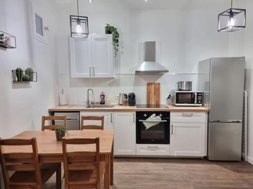 - une cuisine avec des placards blancs, une table et un réfrigérateur dans l'établissement Cosy Apartments - Marseille Panier Intercontinental - City center, à Marseille