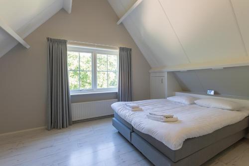 - une chambre avec un grand lit et une fenêtre dans l'établissement Hello Zeeland - Appartement Brouwerijweg 43-2, à Domburg