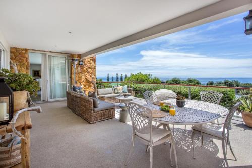 a patio with a table and chairs and a view of the ocean at Far Horizons Camps Bay in Cape Town