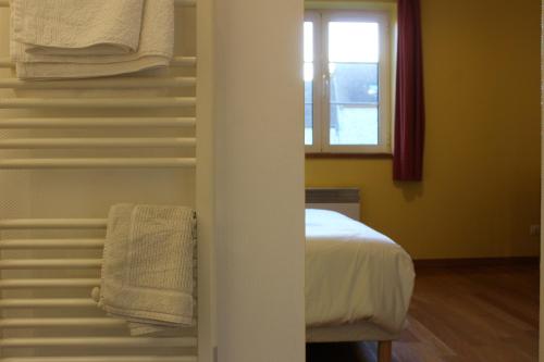 a bedroom with a bed and a window and towels at La Bullote - Gîtes - Paris Roissy CDG in Villeneuve-sous-Dammartin
