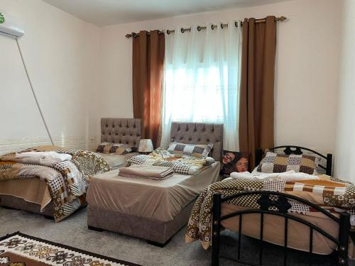 Habitación con 2 camas y 1 niño en el suelo en Its your choice hostel, en Wadi Musa