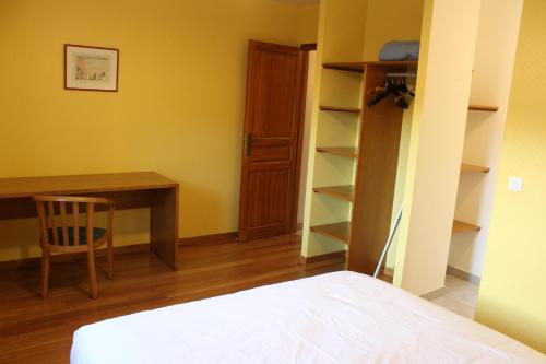 a bedroom with a desk and a bed and a table at La Bullote - Gîtes - Paris Roissy CDG in Villeneuve-sous-Dammartin