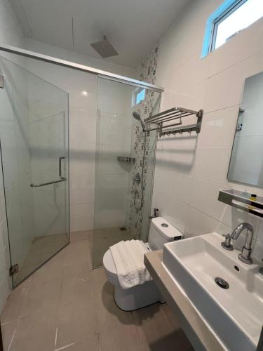 een badkamer met een douche, een toilet en een wastafel bij Airis Sanctuary Resort in Pantai Cenang
