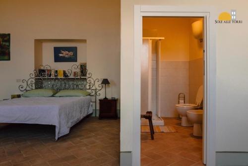 a bedroom with a bed and a bathroom with a toilet at Appartamenti Sole alle Torri in Assisi