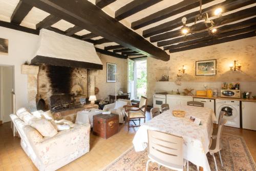 un salon avec une table et une cheminée dans l'établissement Le Tertre, à Dureil