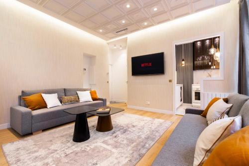 un salon avec un canapé et une télévision sur un mur dans l'établissement Sumptuous apartment - 1BR-6P - Bourse, à Paris