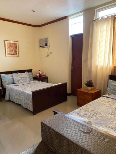 a bedroom with two beds and a window at S&E Apartment unit, Lapaz, Iloilo city in Iloilo City