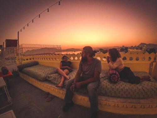 a group of people sitting on a bed with the sunset at Hostel Mantra in Udaipur