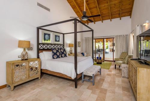 una camera da letto con letto a baldacchino e un soggiorno di Casa de Campo Luxury Villas - Private Paradise at La Romana a La Romana