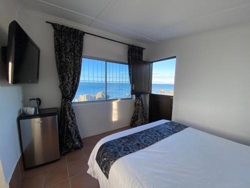 a bedroom with a bed and a large window at The Beach Shack Glamping & The Boat Shed in St Helena Bay