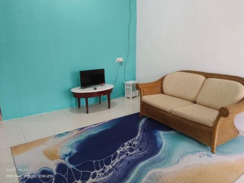 een woonkamer met een bank en een tafel bij EMBUN 2 LANGKAWI HOMESTAY in Pantai Cenang