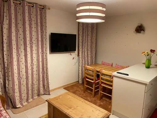 une cuisine et une salle à manger avec une table et un réfrigérateur dans l'établissement Studio montagne Demi Quartier, à Demi-Quartier