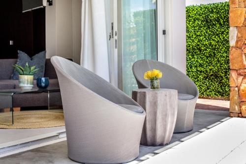 a living room with two chairs and a table at Far Horizons Camps Bay in Cape Town