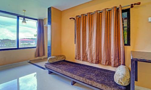 a living room with a bench and a window at Treebo Vhyomaan Resort in Mahabaleshwar
