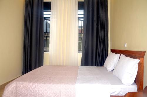 - une chambre avec un lit en face d'une fenêtre dans l'établissement Sunny Hill Apartments, à Kigali