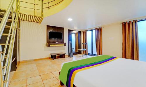 a bedroom with a bed and a television and a ladder at Treebo Vhyomaan Resort in Mahabaleshwar