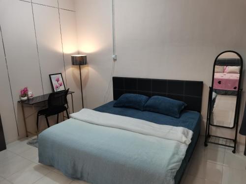 1 dormitorio con cama, mesa y escritorio en VIRTA Guesthouse, en Sandakan