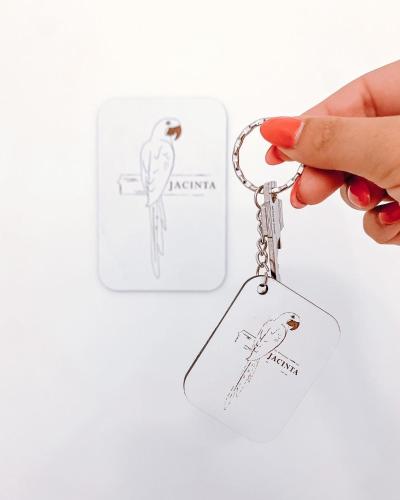 a hand holding a key chain with a drawing of a bird at Ninho D'Arara in Tondela