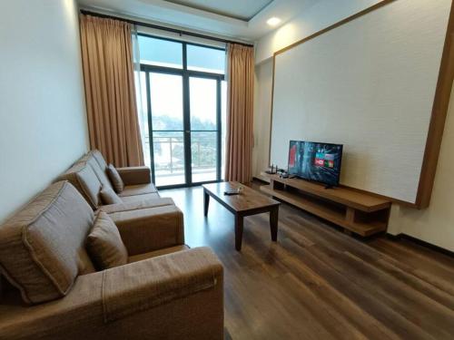 a living room with a couch and a flat screen tv at The Retreat Sweety 3BR H/Stay in Brinchang