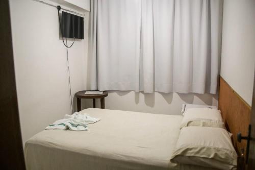 a bedroom with a bed with shoes on it at Pousada Rio Branco Nova Lima in Nova Lima
