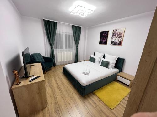 クルジュ・ナポカにあるAparthotel Junior4 Clujのベッドとテレビが備わるホテルルームです。