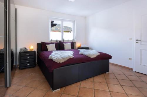 um quarto com uma cama com lençóis e almofadas roxos em Kaminwohnung mit 24qm Südterrasse Nähe Zugspitze / Eibsee em Garmisch-Partenkirchen