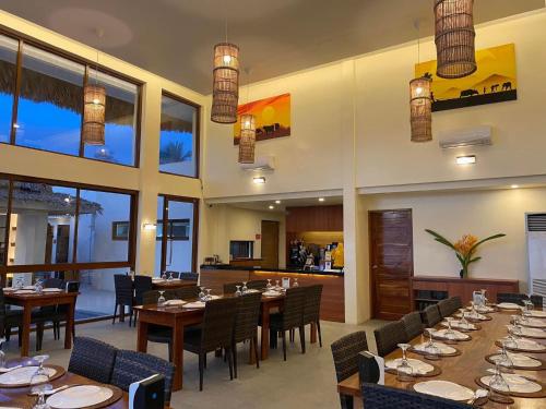 un ristorante con tavoli e sedie in legno e finestre di Beatriz Rafaela Resort 