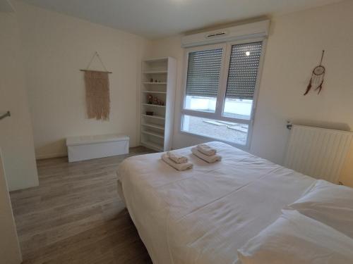 a bedroom with a bed with two towels on it at SAINT DENIS appartement 2 chambres avec parking in Saint-Denis