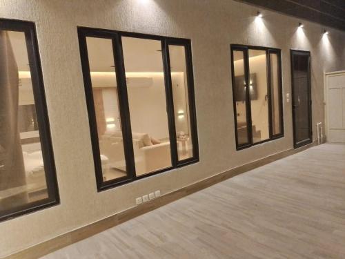 een rij ramen in een kamer met houten vloeren bij همس المدى للشقق المخدومه in Al Ahsa