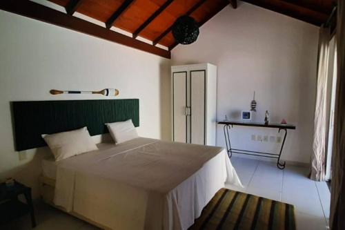 a bedroom with a large bed and a table at VILLA RANIERI in Pipa